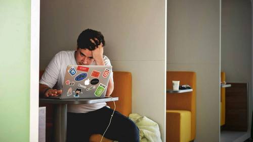 Mann sitzt in Coworking-Space am Laptop