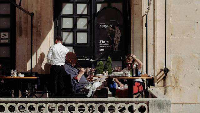 Personen sitzen in Café, Keller im Hintergrund