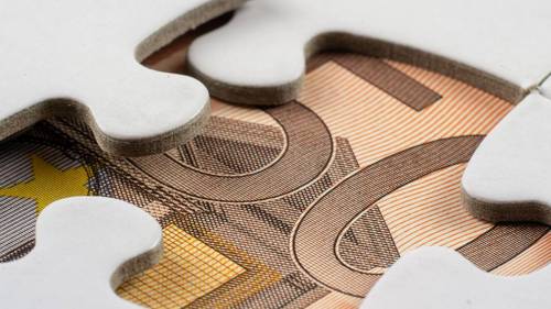 Weiße Puzzleteile liegen auf einem Euro-Geldschein und symbolisieren die Bedingungen eines Zinsangebots.