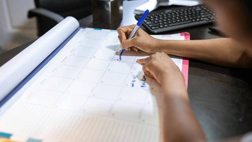 Person schreibt in Kalender