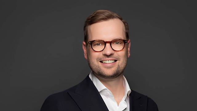 Porträt von Franchise-Experte Jan Schmelzle mit Brille vor dunklem Hintergrund