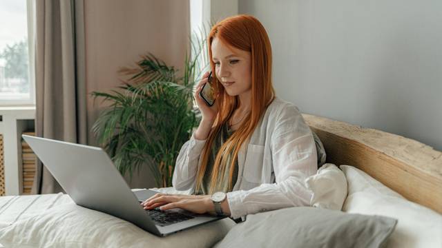 Frau arbeitet im Bett