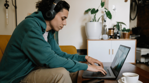 Person mit Kopfhörern am Laptop