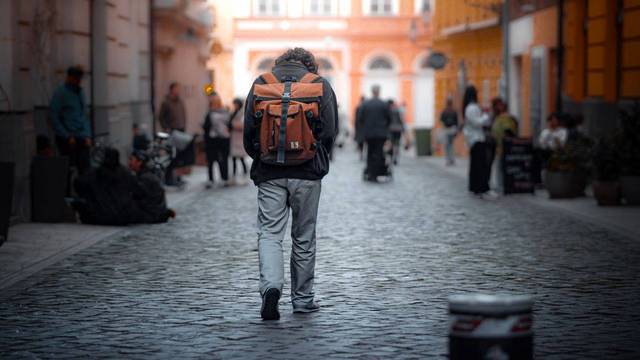 Red Rebane insolvent: Rucksack-Hersteller stellt Produktion ein Person mit Rucksack läuft durch eine gepflasterte Innenstadt